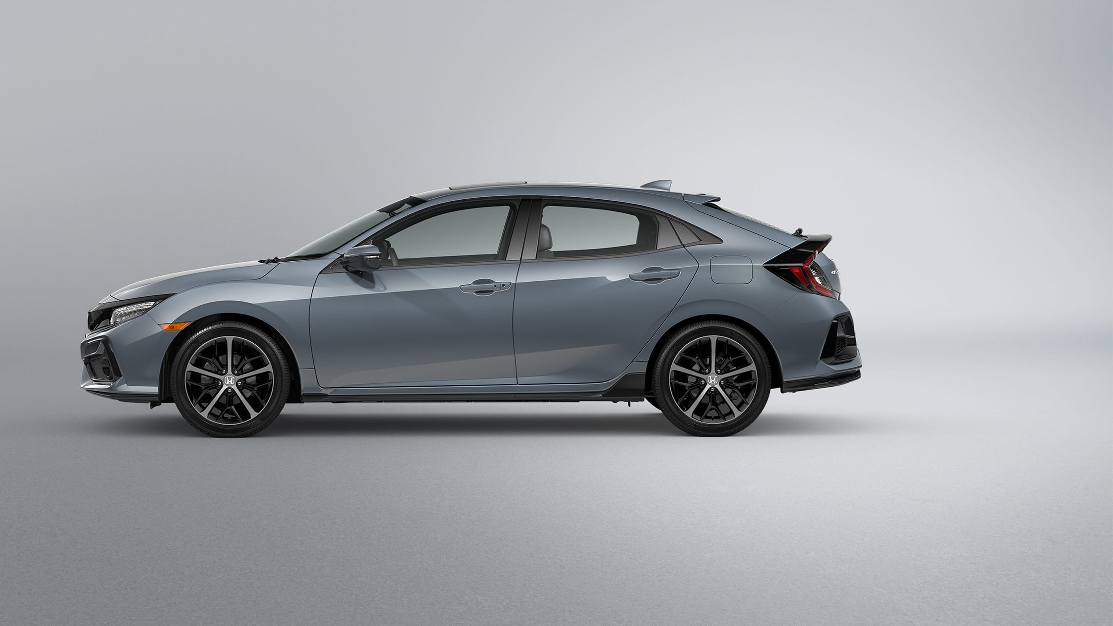 Vista de perfil del lado del conductor del Honda Civic Sport Touring Hatchback 2021 en Sonic Gray Pearl.